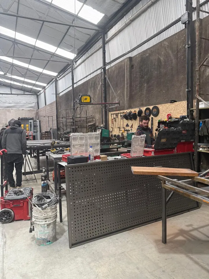 Panel de chapa calada terminado en el taller, con el equipo trabajando detrás